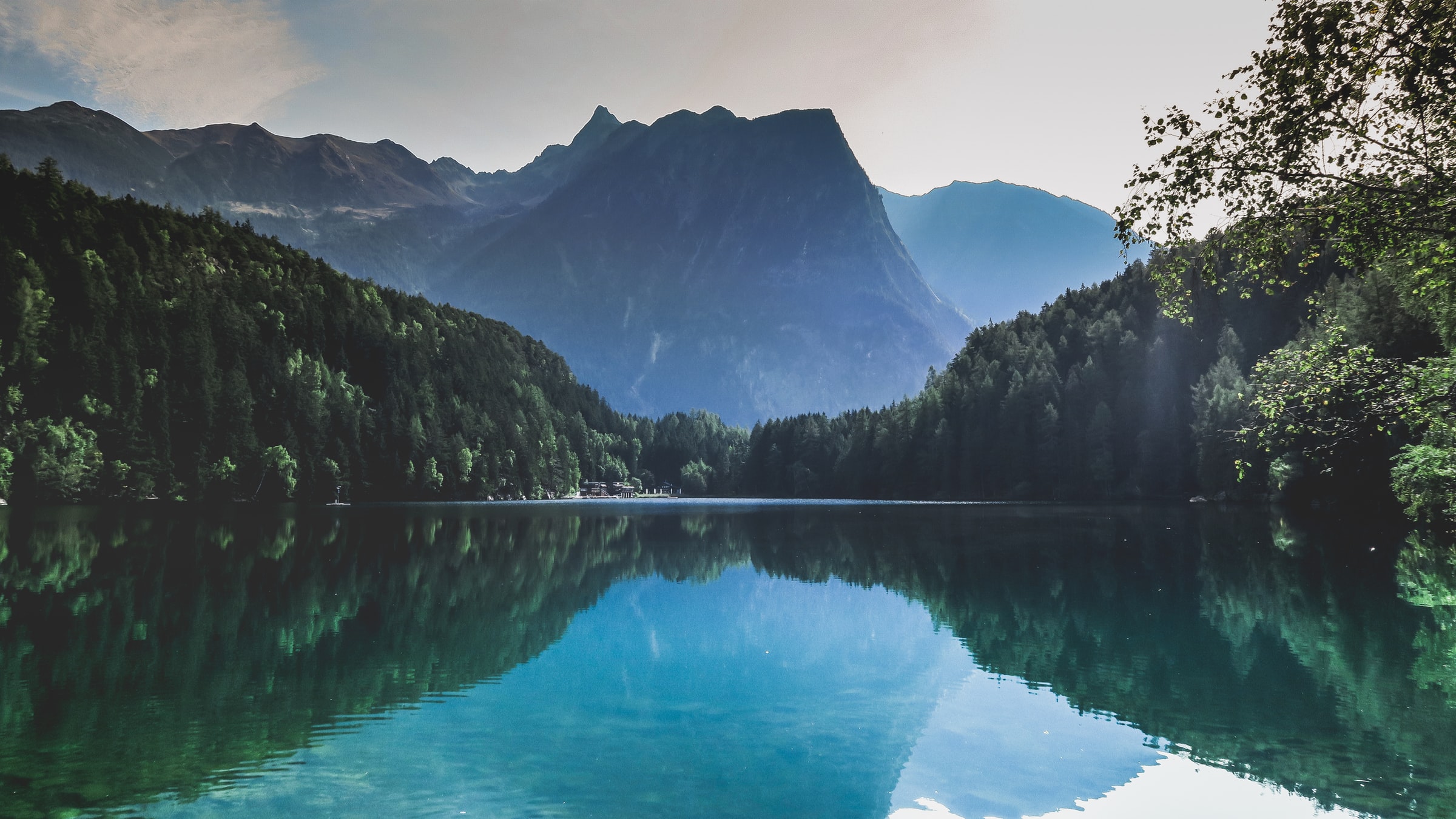 Wald um den See herum mit einem Berg im Hintergrund